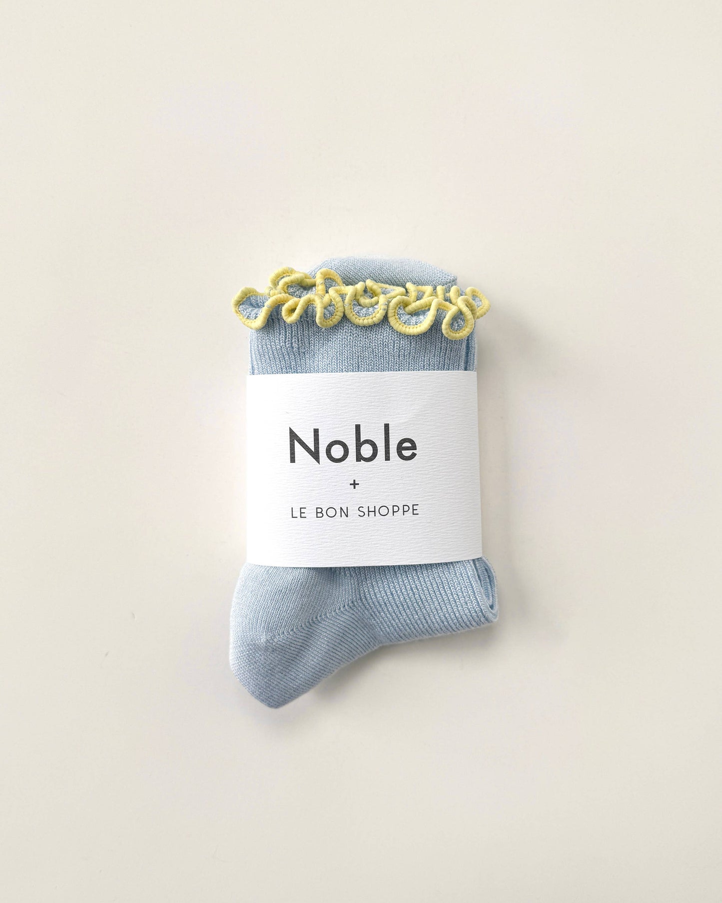 Blue socks with a 'Noble' label on a beige background