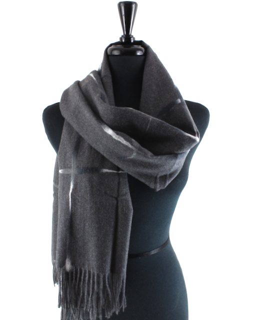 A dark gray plaid scarf with fringe, draped on a black mannequin torso against a white background.