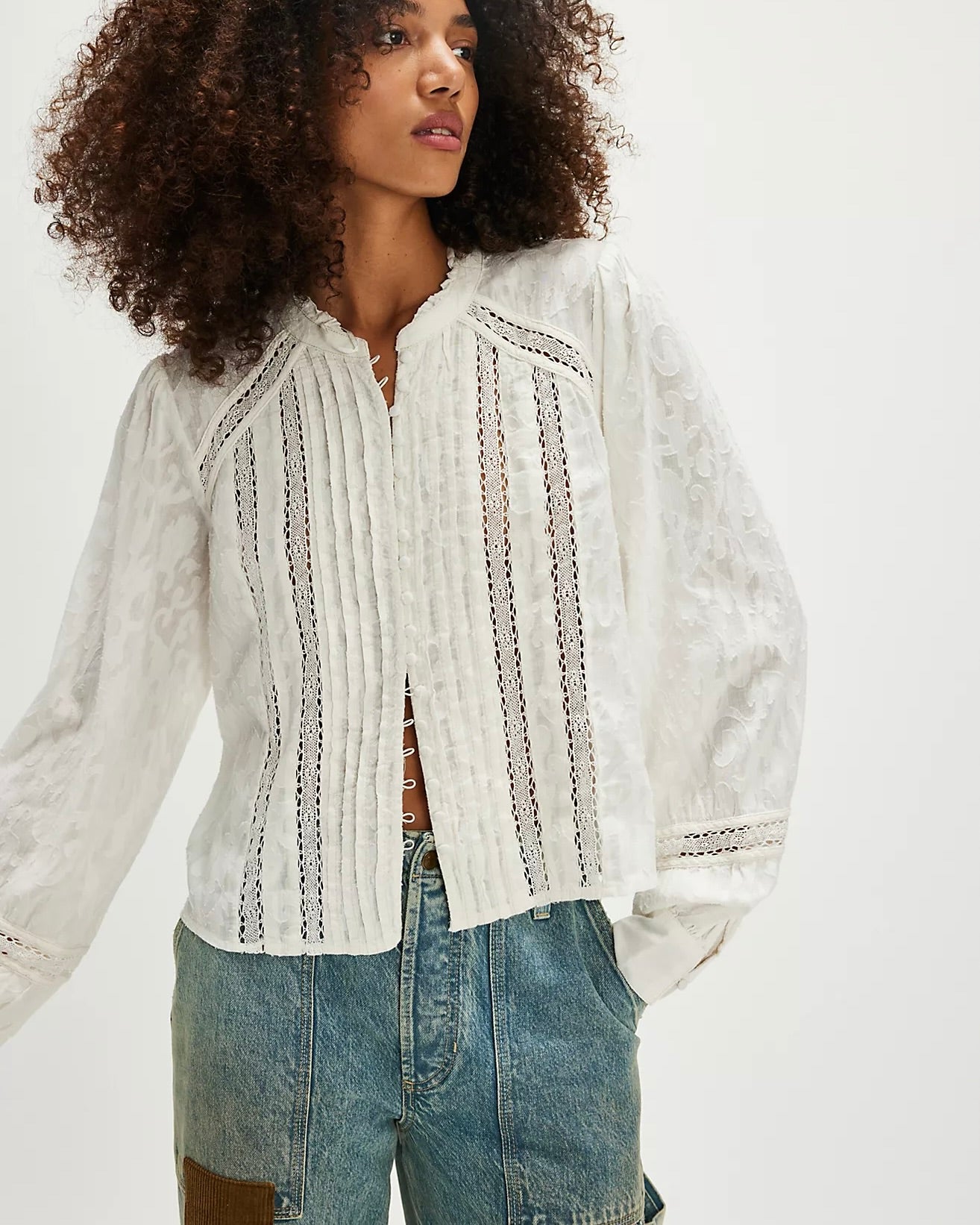 Model wearing Free People Annabelle Blouse in white wearing jeans on a white background 