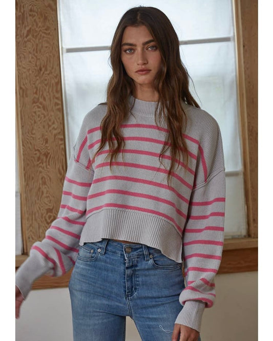 Model wearing By Together Pink/gray Striped Crop Sweater wearing jeans standing in front of window