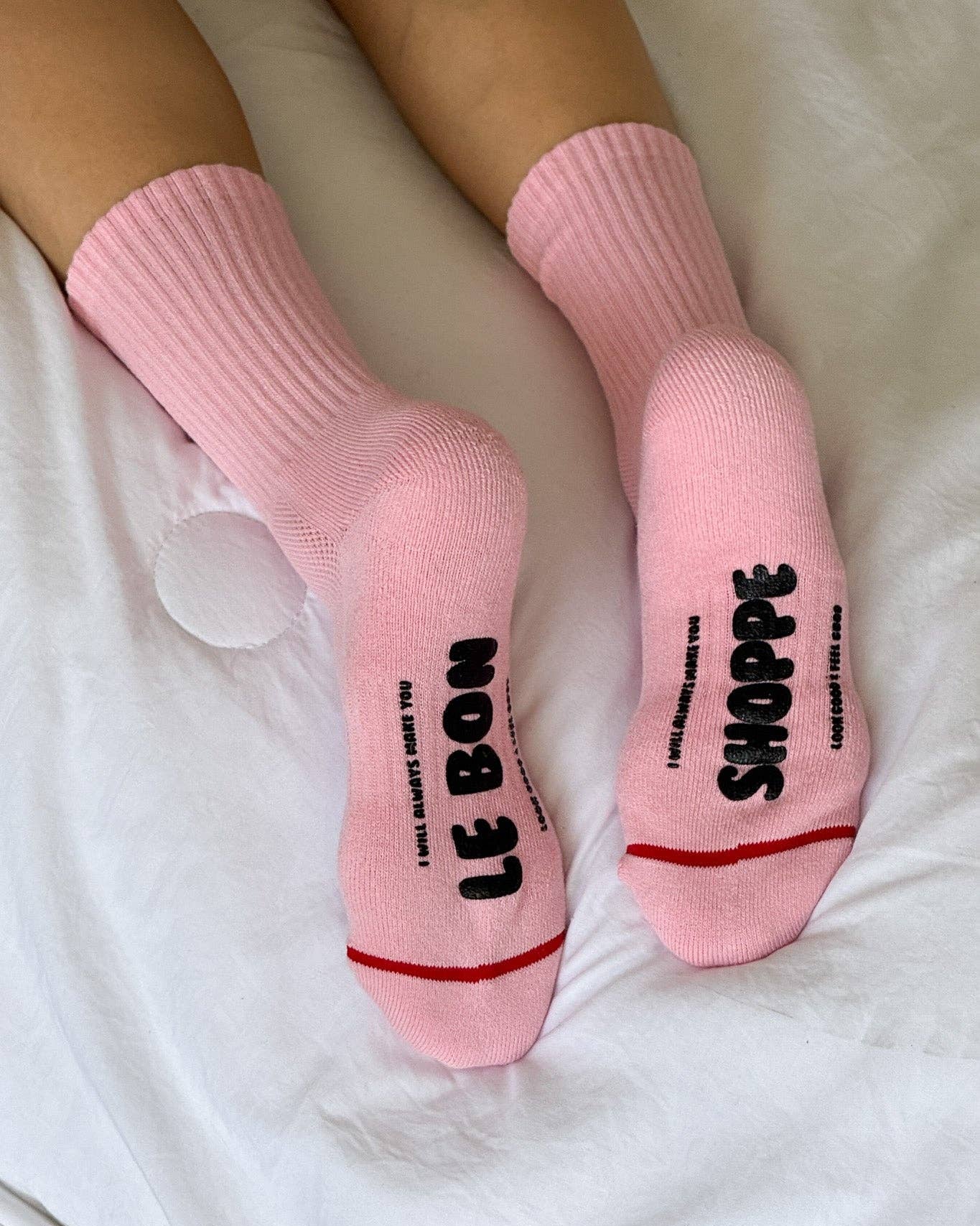 Pink socks with text on a white surface