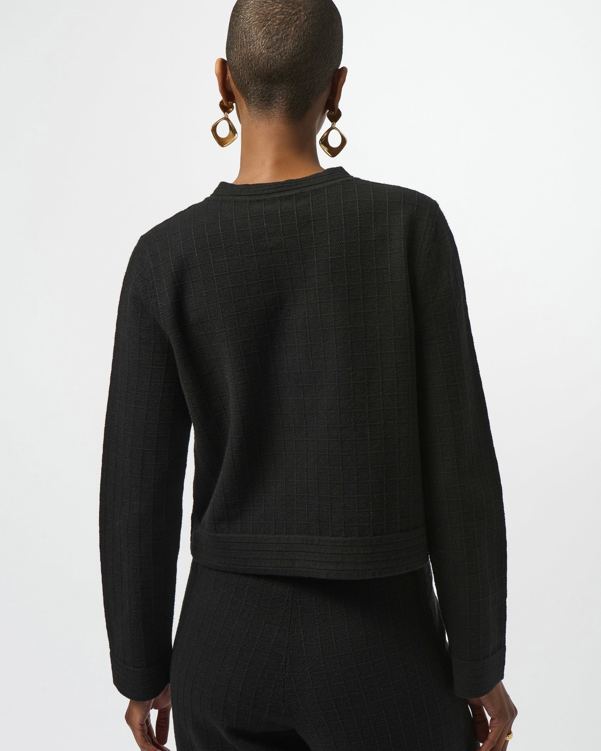 Model is wearing Joseph Ribkoff Sweater Knit Button Front Jacket in black with black knit pants on a white background