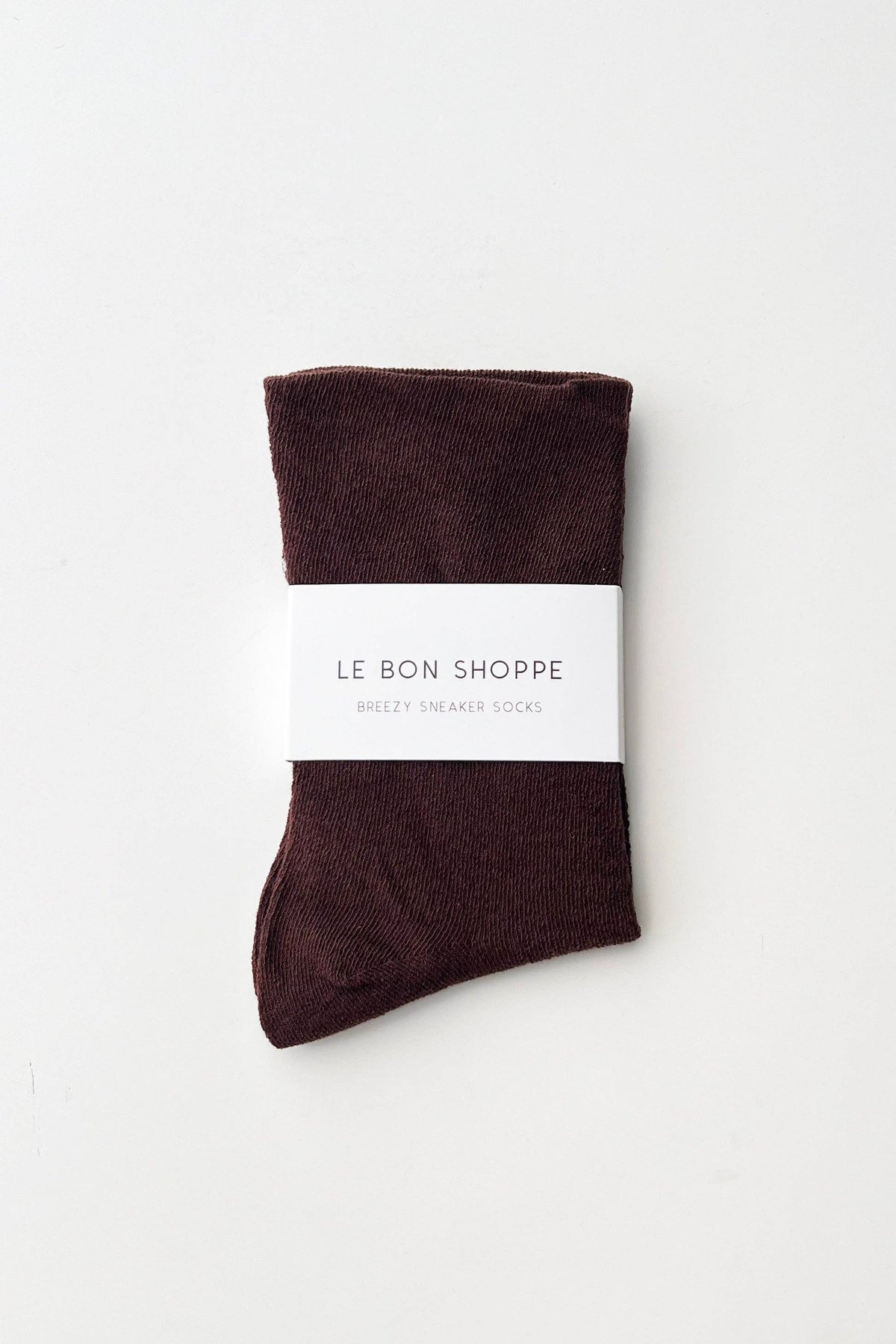 Brown sock with a white label on a light gray background