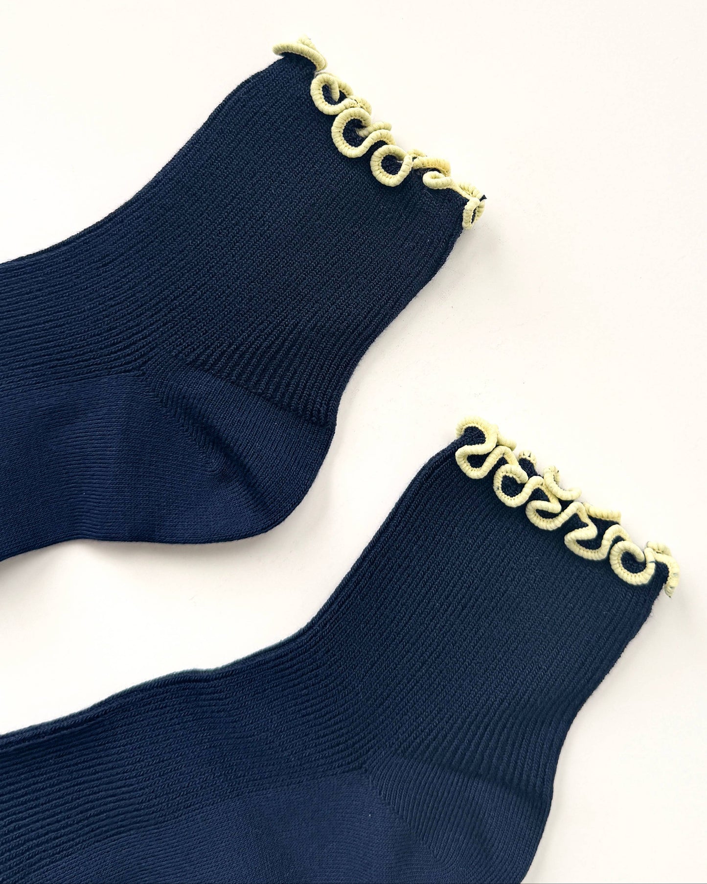 Navy socks with gold chain detail on a white background