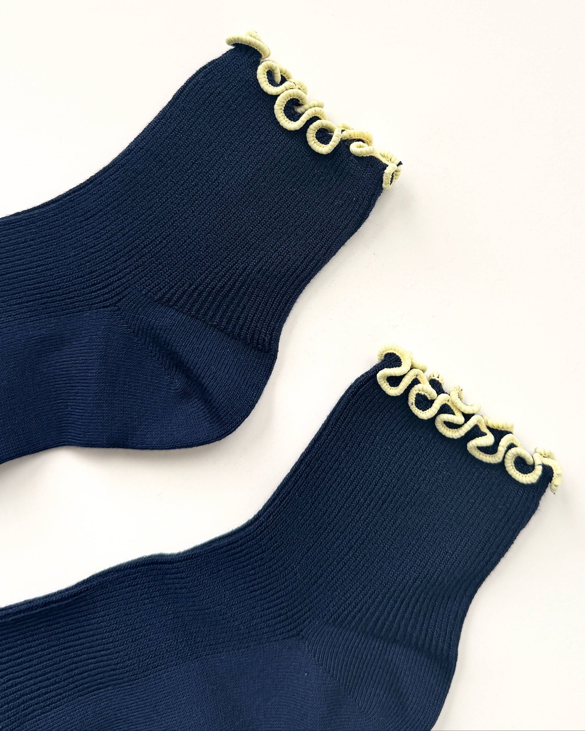 Navy socks with gold chain detail on a white background