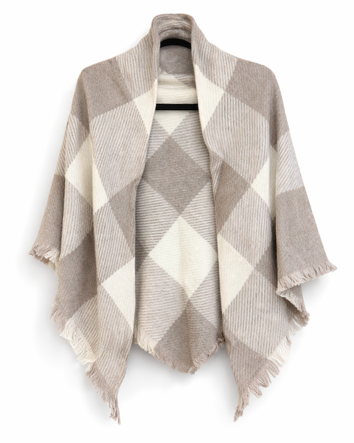 A beige and cream plaid open-front wrap poncho with fringed edges, displayed on a hanger against a plain white background.