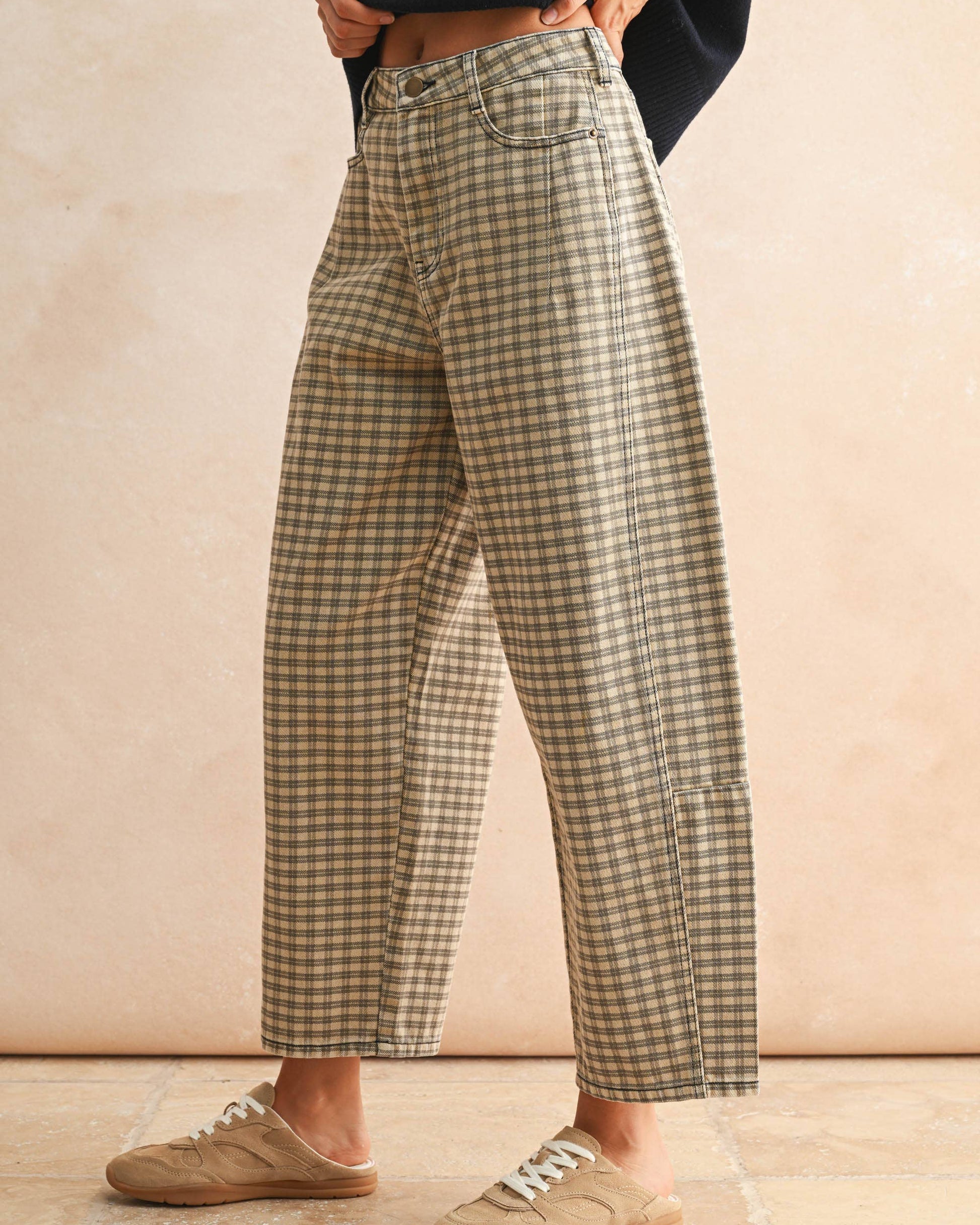 Person wearing plaid pants and slippers on a beige background
