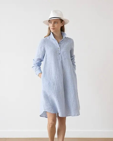 Front view of model wearing the LinenMe Linen Stripe Tee Dress in light blue with a white hat, standing against a white background