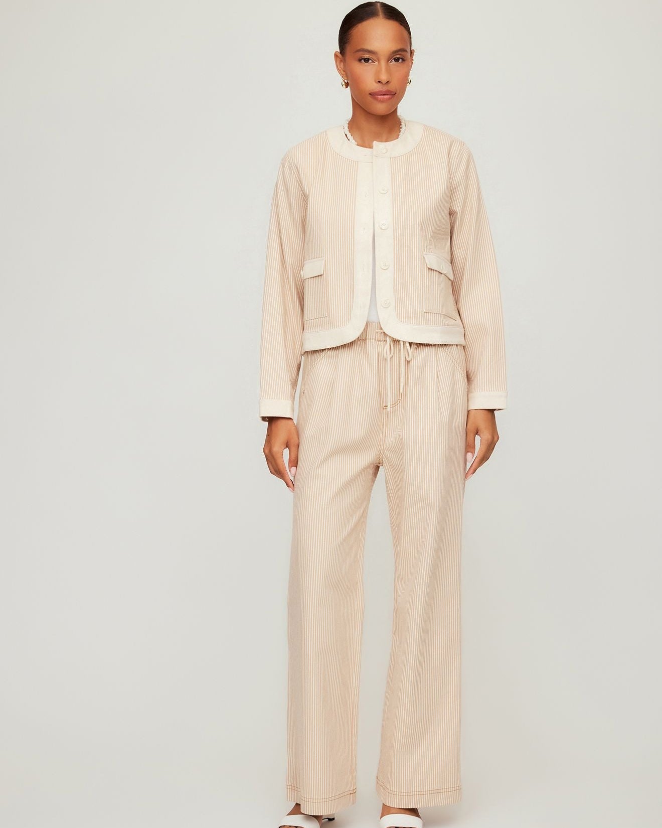 Woman wearing a beige suit on a plain background