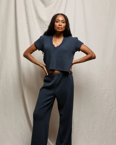 Woman wearing a navy blue outfit against a plain background