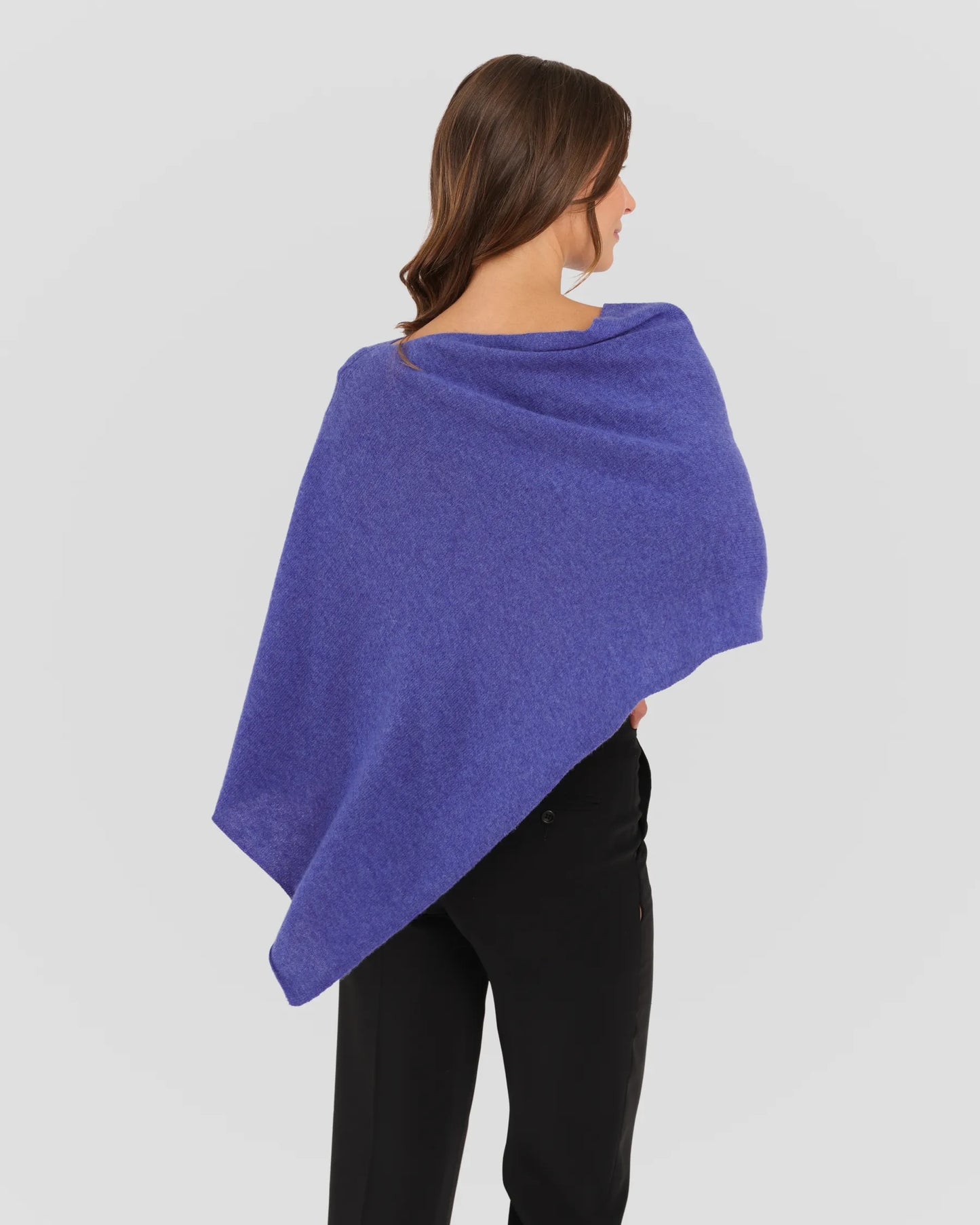 Woman wearing a purple shawl on a plain background