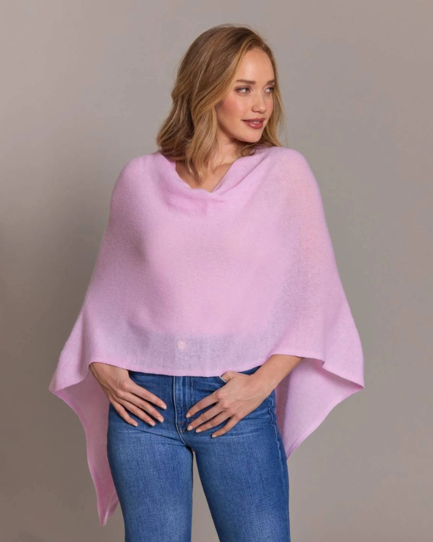Woman wearing a light purple poncho over a gray background