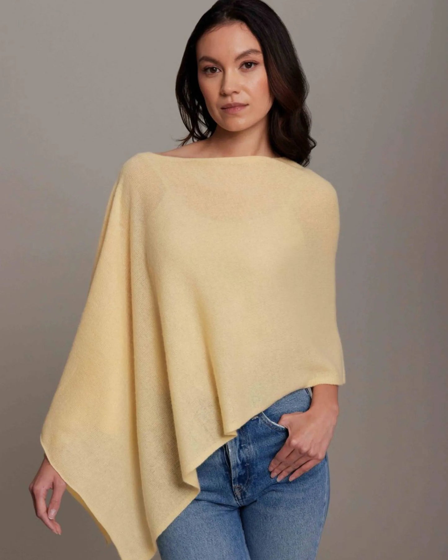 Woman wearing a yellow poncho over a plain background