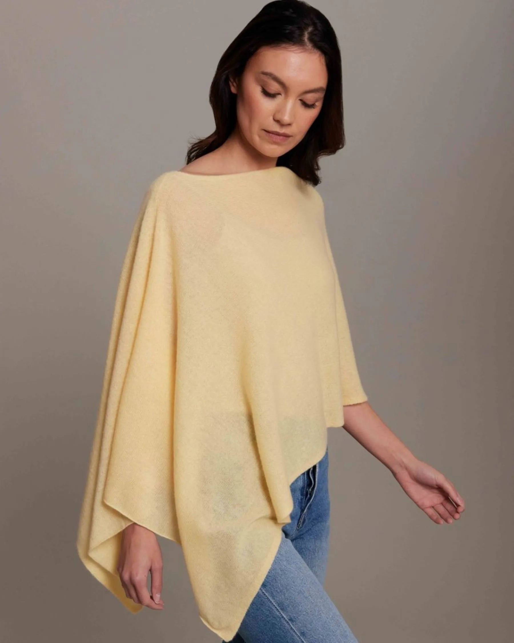 Woman wearing a yellow poncho against a gray background