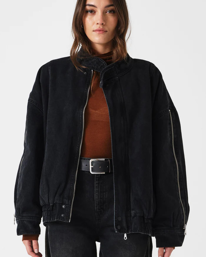 Person wearing a black jacket over a brown shirt on a white background