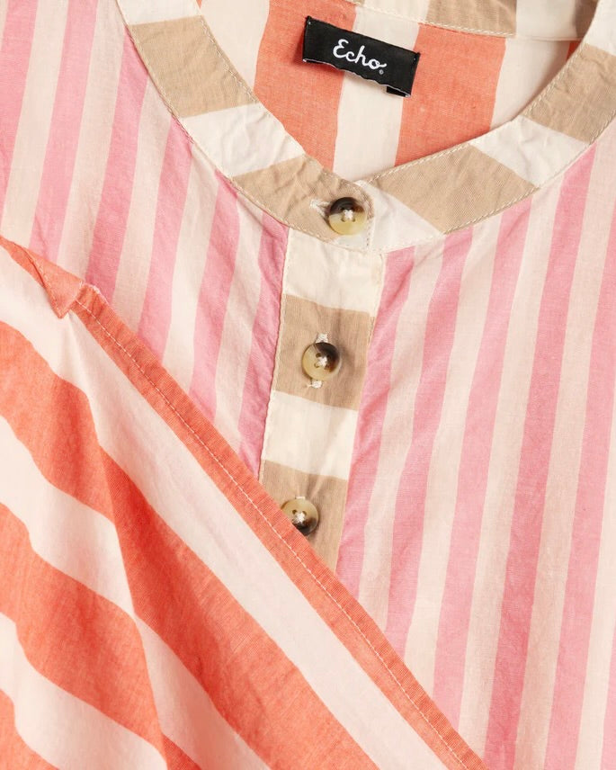 Close-up of a striped shirt with a brand label on a pink and white background