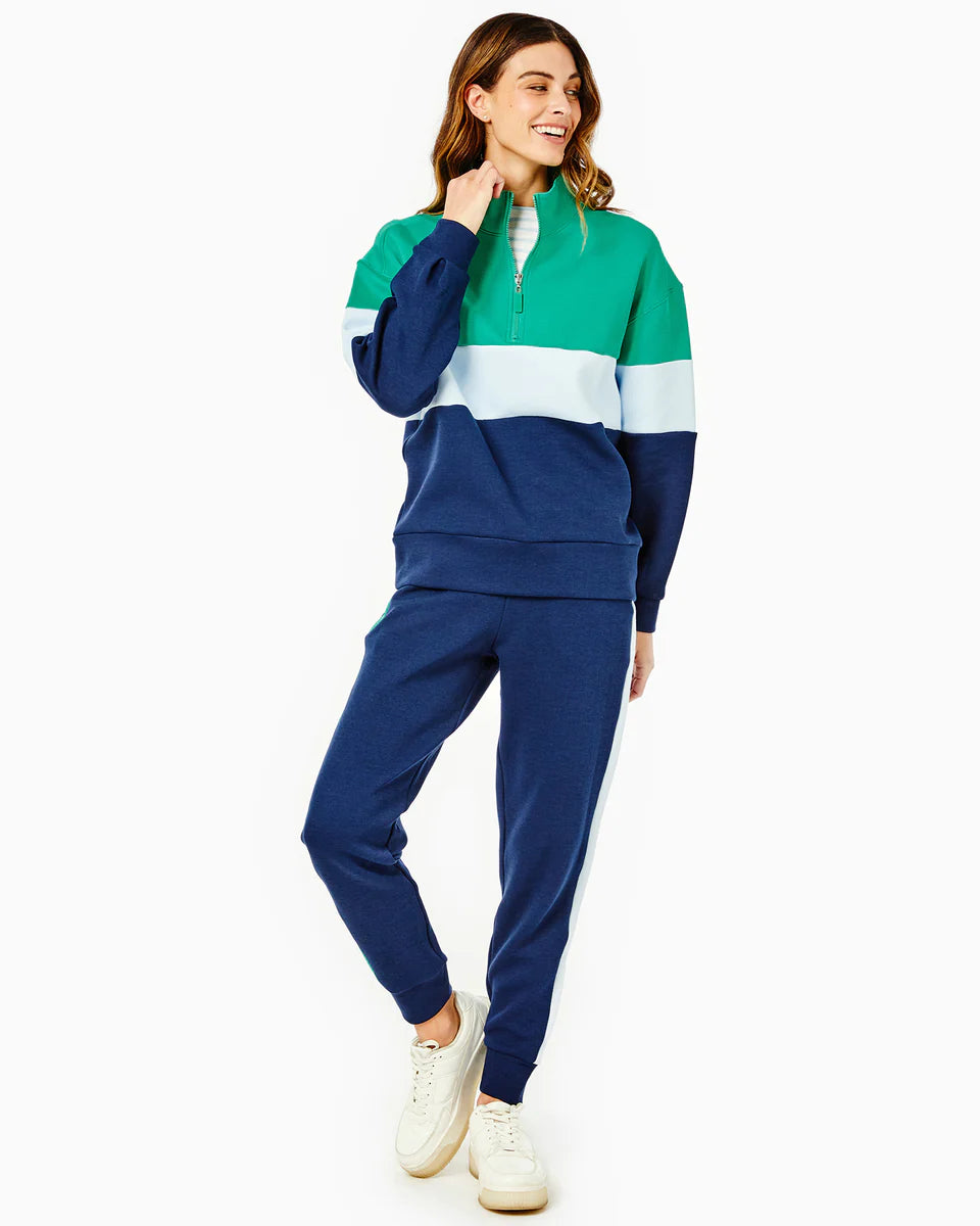 Model wearing Addison Bay Varsity Quarter Zip Sweatshirt wearing blue sweatpants on a white background