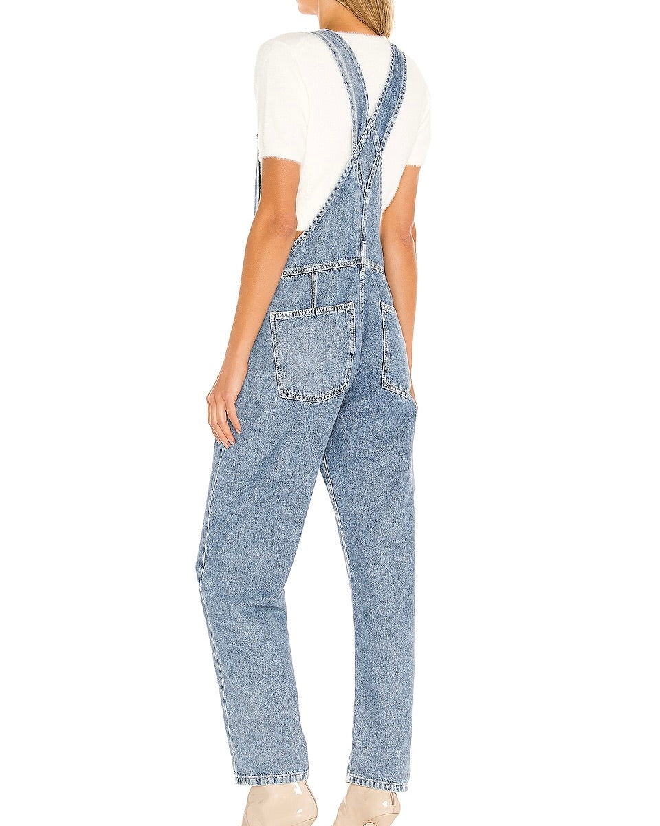 Model wearing Free People Ziggy Denim Overalls in Powder Blue Denim wearing white tee and white boots on a white background