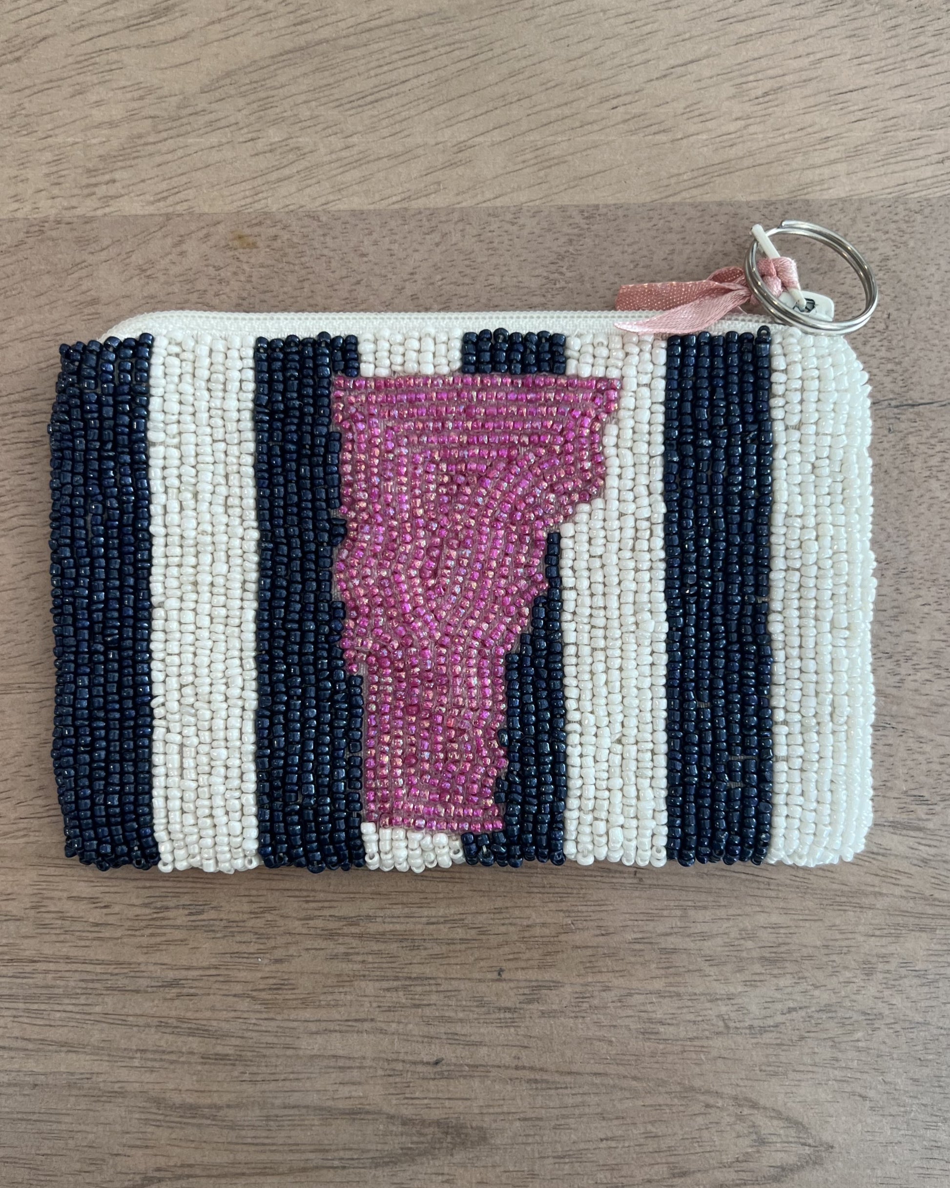 Image of Middlebury Vermont State Coin purse with pink and blue/white stripes on a brown background