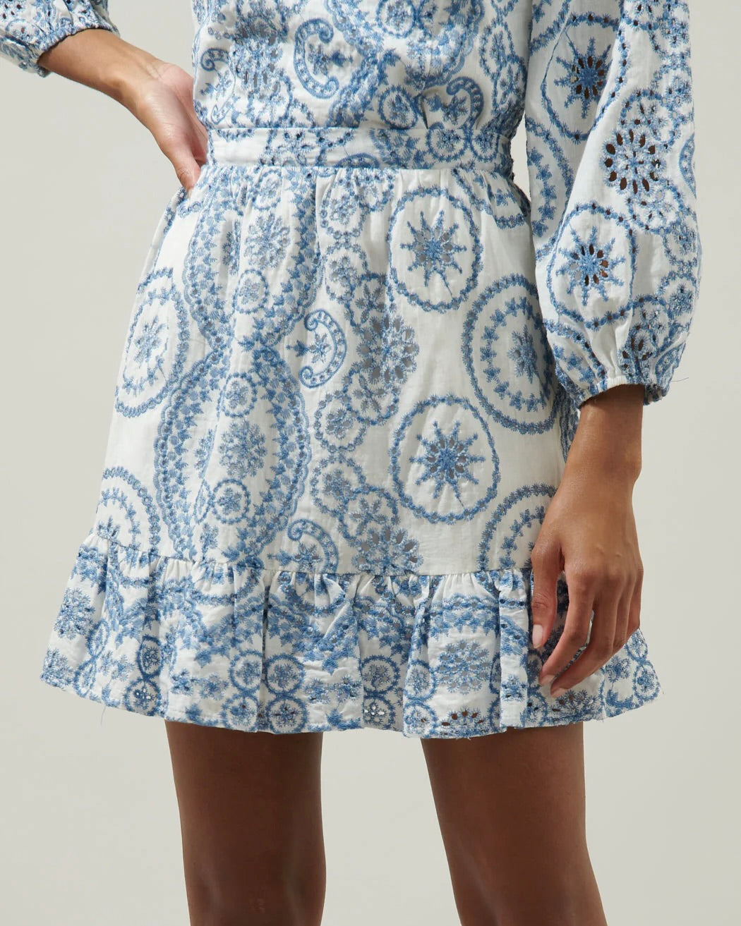 Model wearing Adelaide Border Print Eyelet mini skirt-white/blue on a white background
