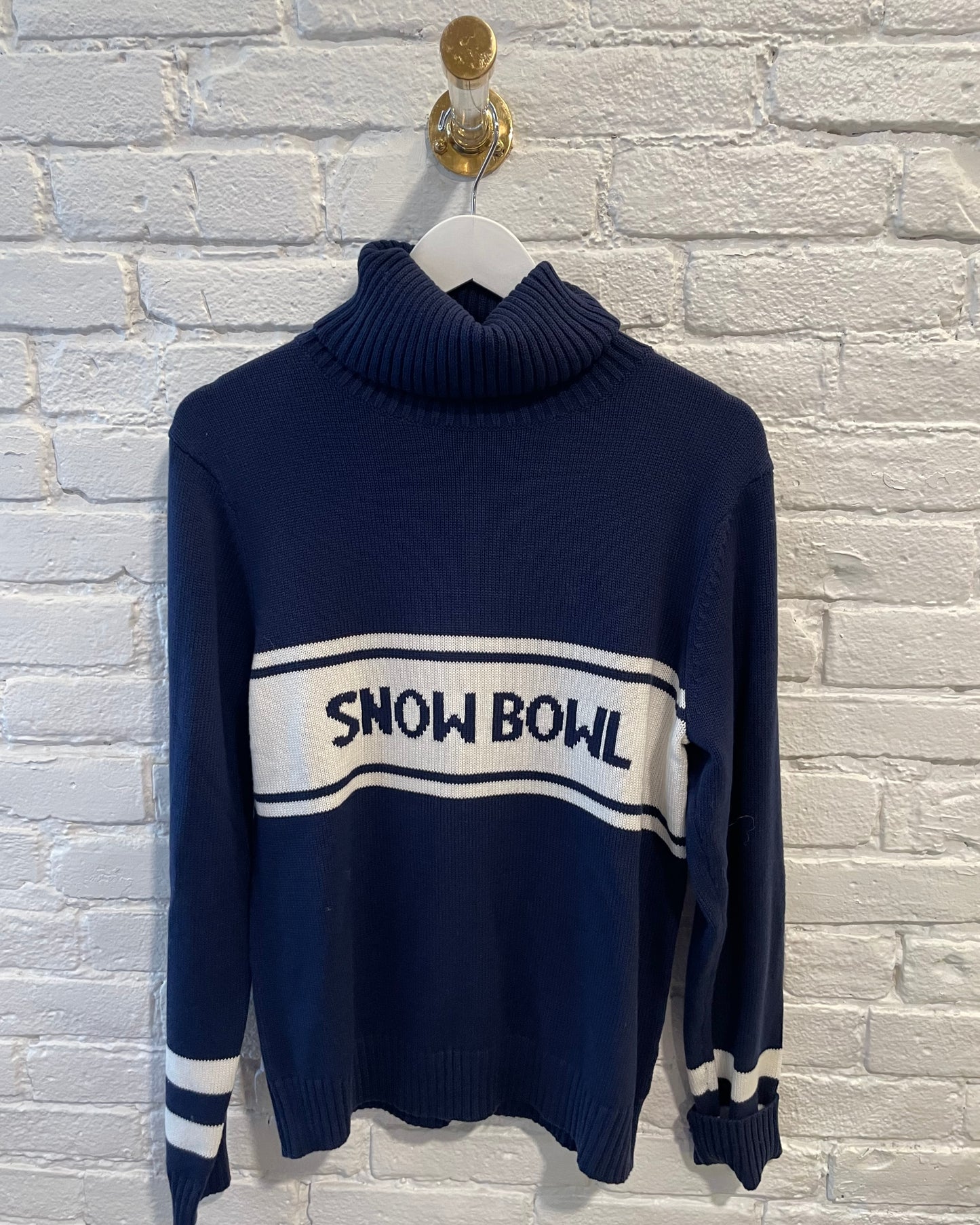 Image of Middlebury Vermont Snow Bowl blue and white sweater on a white brick background