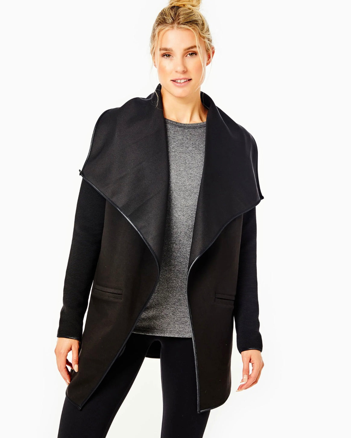 Model wearing Addison Bay The Wrap jacket in Black wearing black leggings and gray shirt on a white background