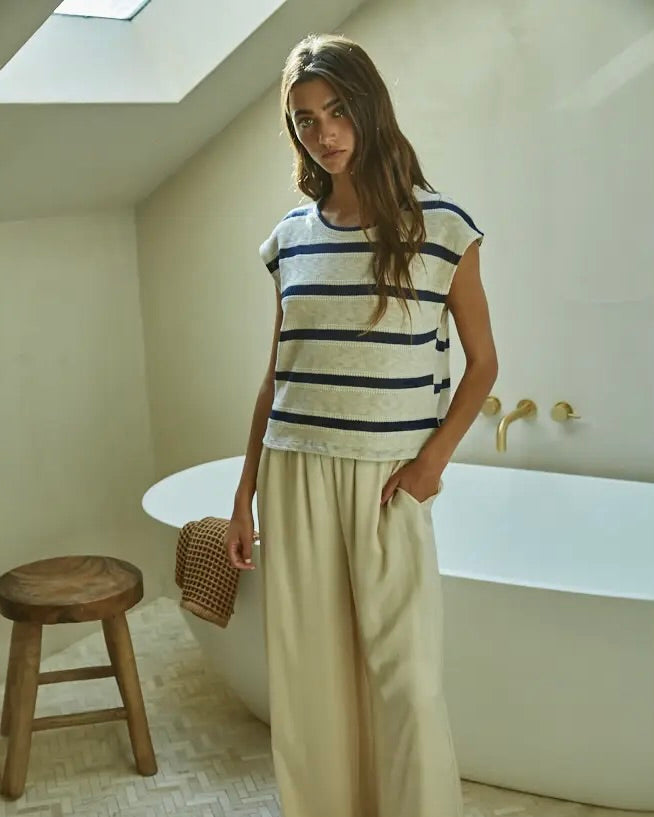 Model wearing By Together Knit Hacci Striped Round Neck Sleeveless Top Wearing white pants standing in a bathroom