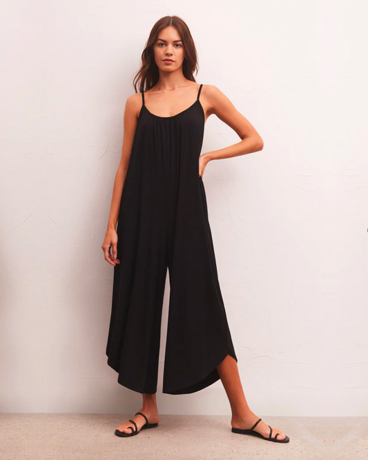 Model wearing Z Supply Black Flared Jumpsuit wearing black sandals on a white background