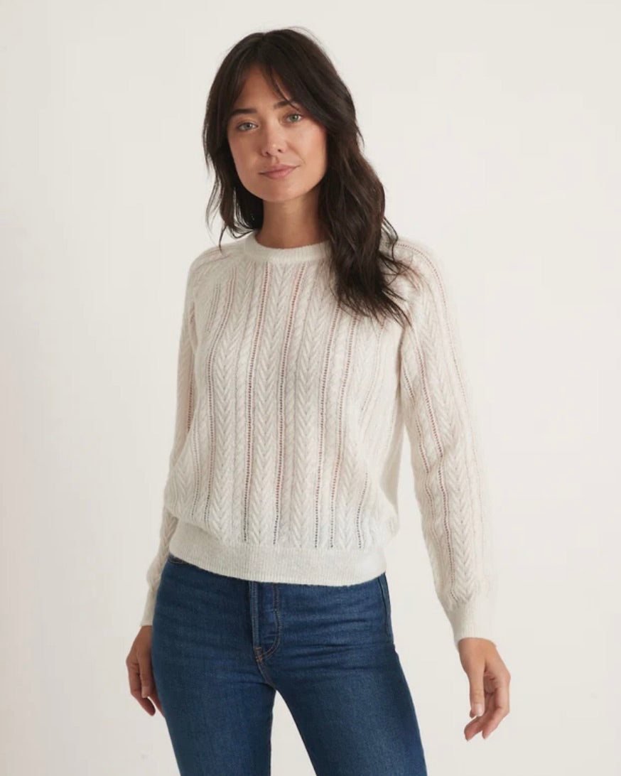 Model wearing Marine Layer Ashton Pointelle sweater in white wearing jeans on a white background 