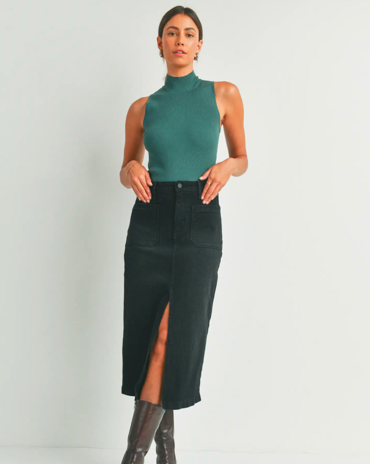 Model wearing Just Black Denim Black utility pocket midi denim skirt in wearing green tank top on a white background