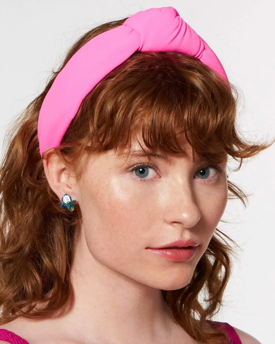 Model wearing Lele Sadoughi Magenta Neoprene Headband on a white background