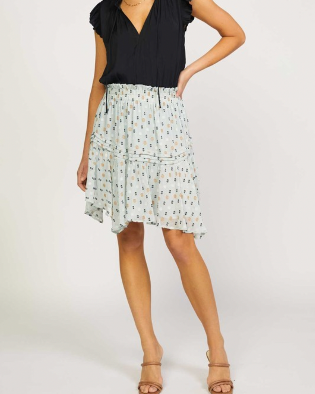 Model wearing Current Air Dusty Mint Dotted Mini Skirt wearing black tank top and brown sandals on a white background
