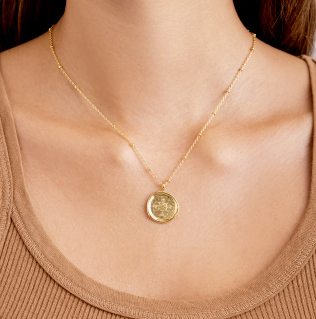 Model wearing Gorjana Compass Coin Necklace in gold 