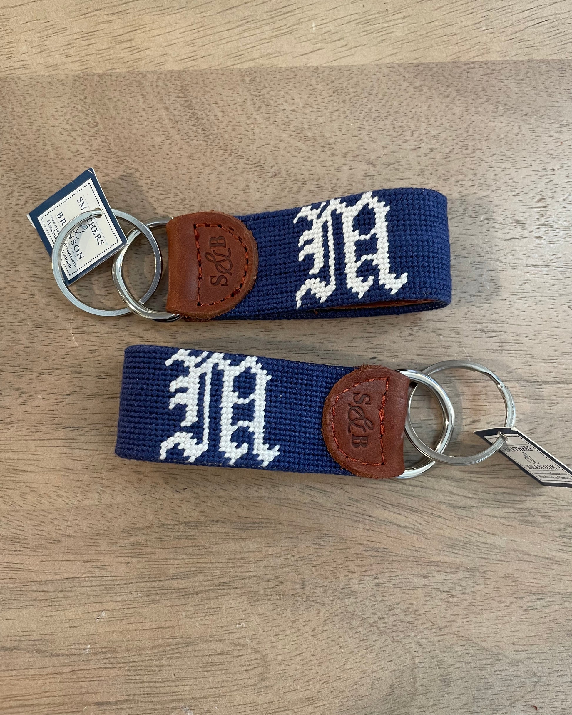 Image of Middlebury College Baseball key chain in Navy/white on a brown background