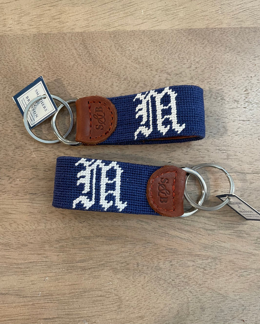 Image of Middlebury College Baseball key chain in Navy/white on a brown background