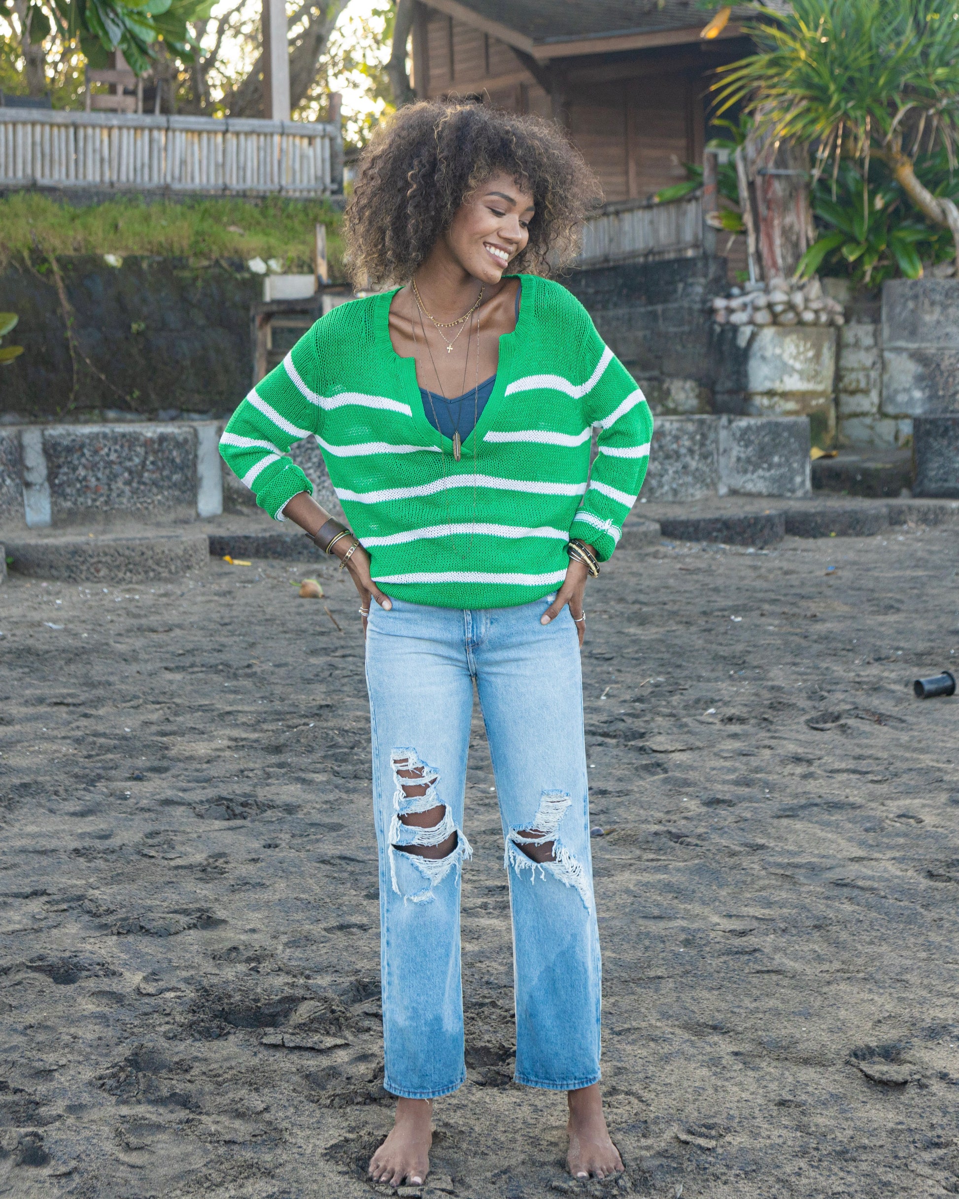 Model wearing Wooden Ships Margot Stripe Top in emerald and white wearing jeans standing outside