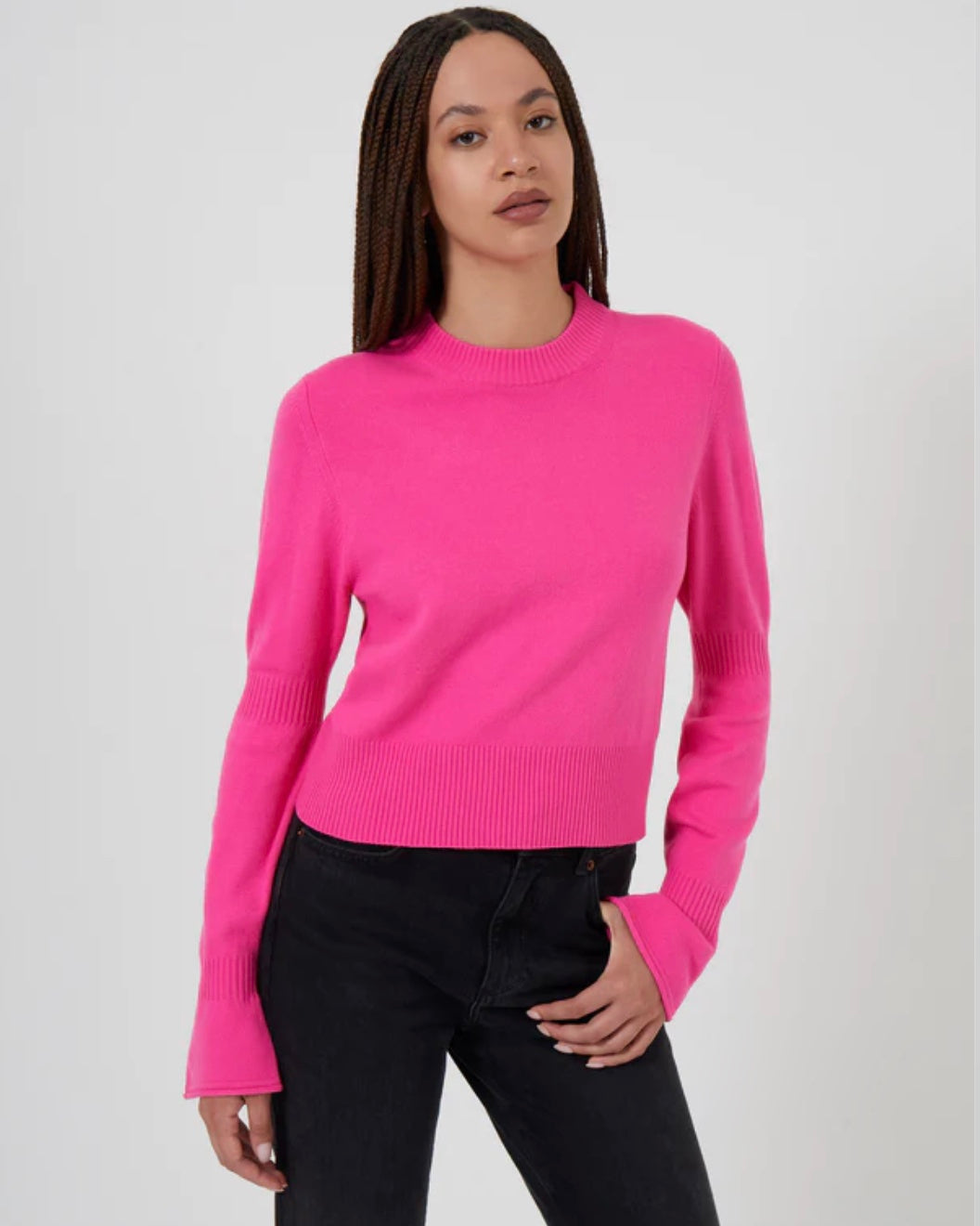 Model wearing French Connection Babysoft Crewneck Gather Jumper sweater in Prosecco pink wearing black jeans on a white background