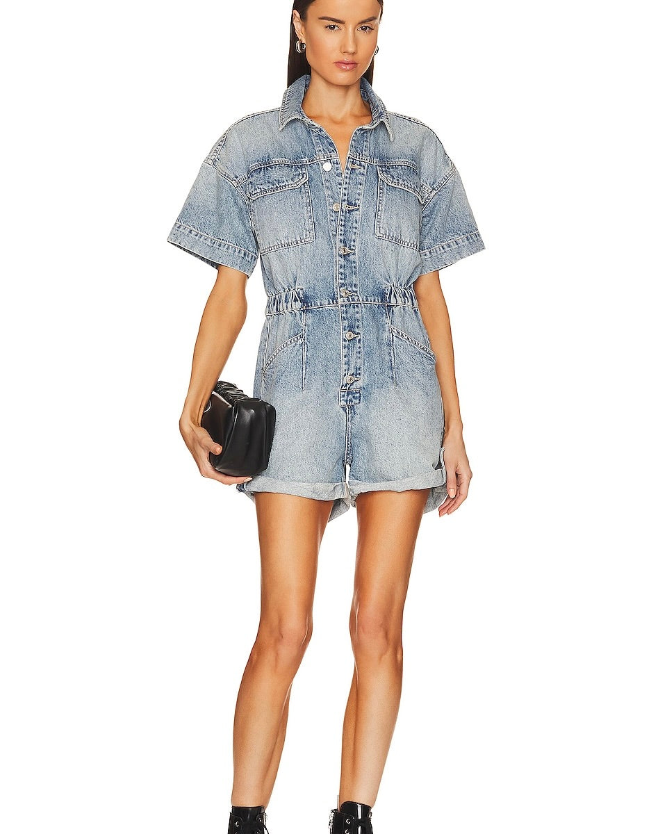 Model wearing Free People We The Free Marci Cuffed Shortall denim holding a black purse on a white background