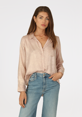Model wearing Dylan pink subtle shimmer siena shirt wearing jeans on a white background