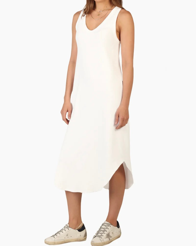 Model wearing Dylan Deep V Dress in white wearing sneakers on a white background