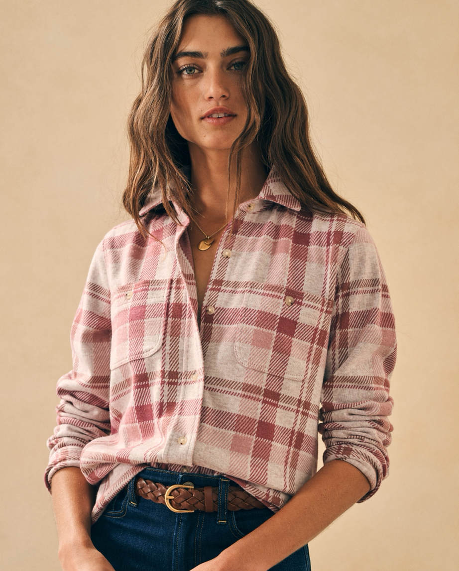 Model wearing Faherty Legend sweater shirt Amelia Plaid wearing jeans and brown belt on a beige background