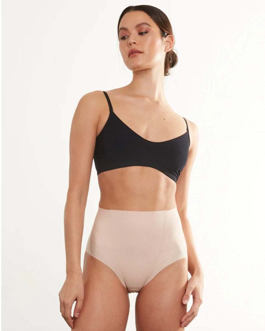 Model wearing Commando zone smoothing brief wearing a black bra on a white background