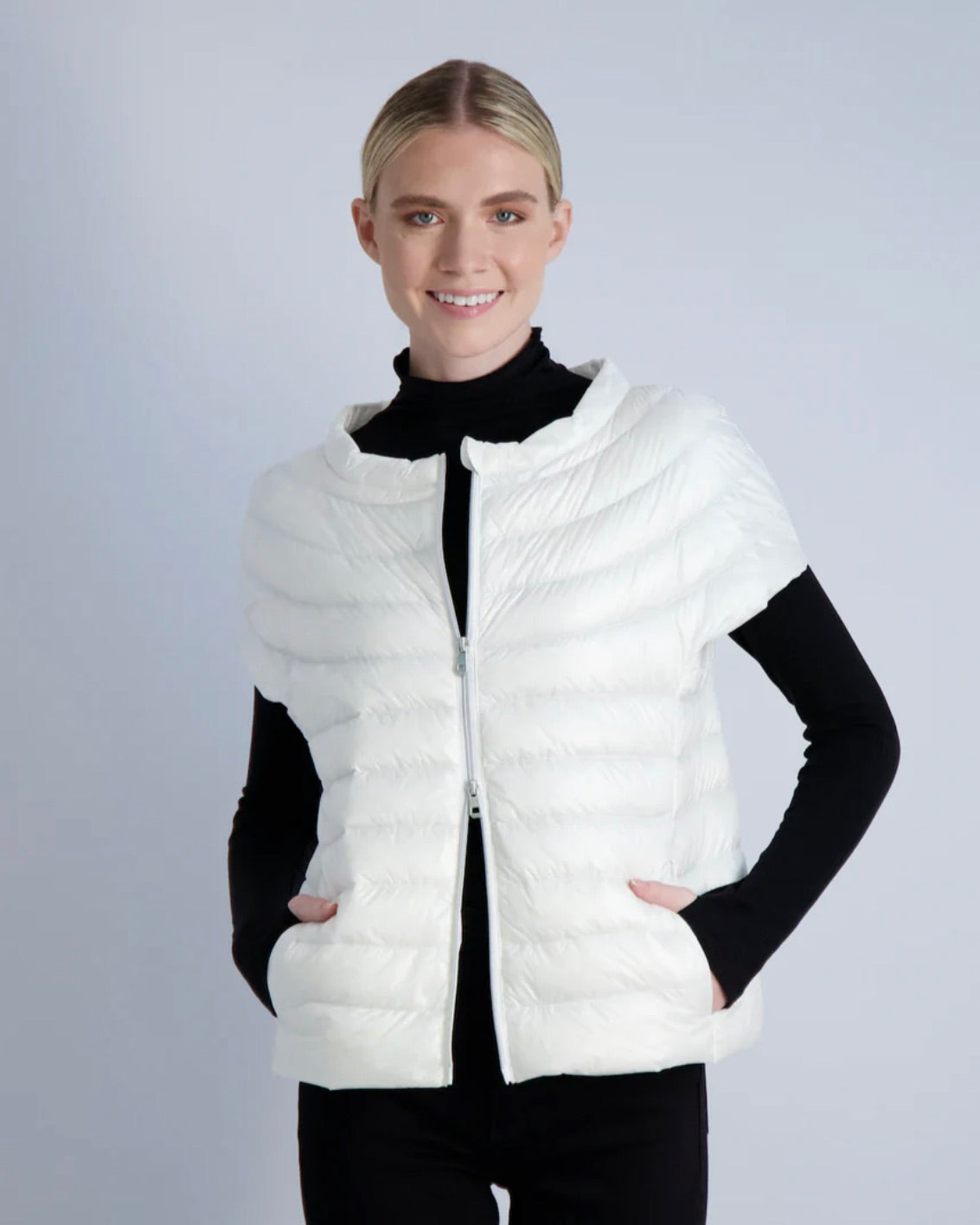 Model wearing Cotes Of London The St Ives Down Vest in Ivory wearing black long sleeve shirt and black pants on a  white background