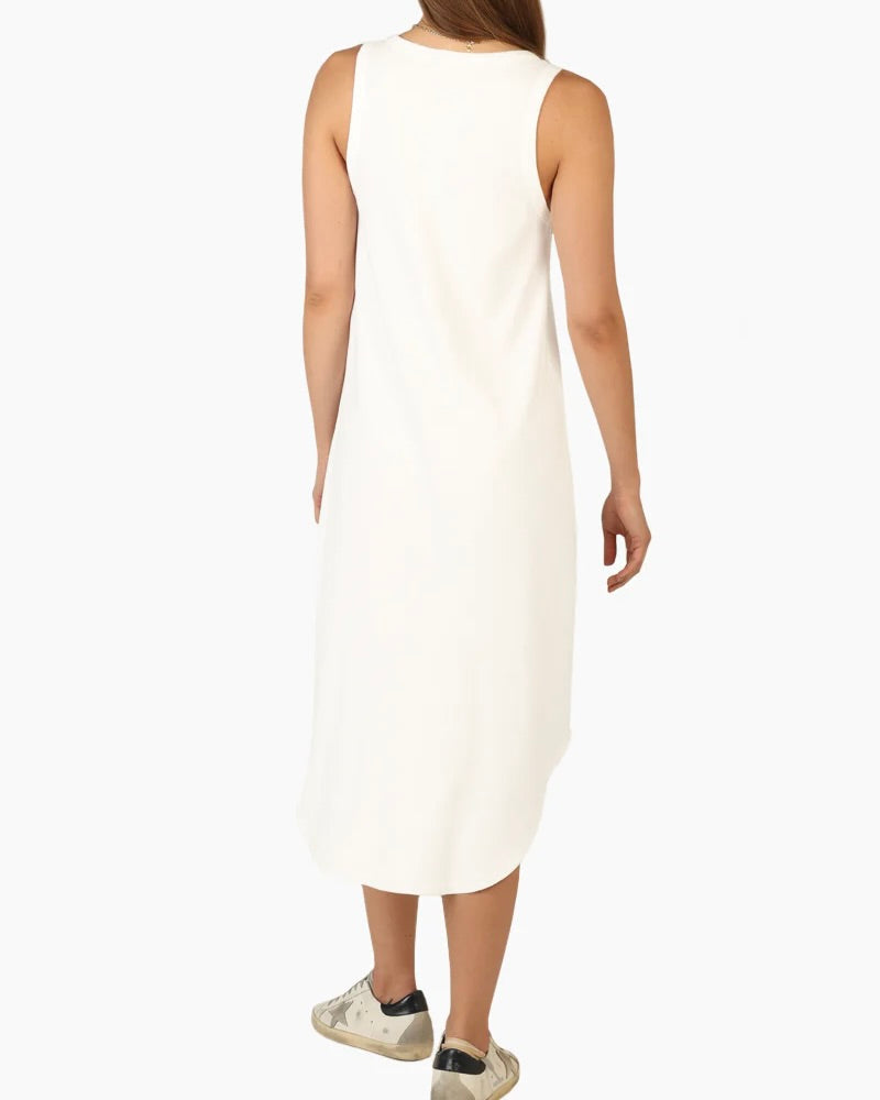 Model wearing Dylan Deep V Dress in white wearing sneakers on a white background