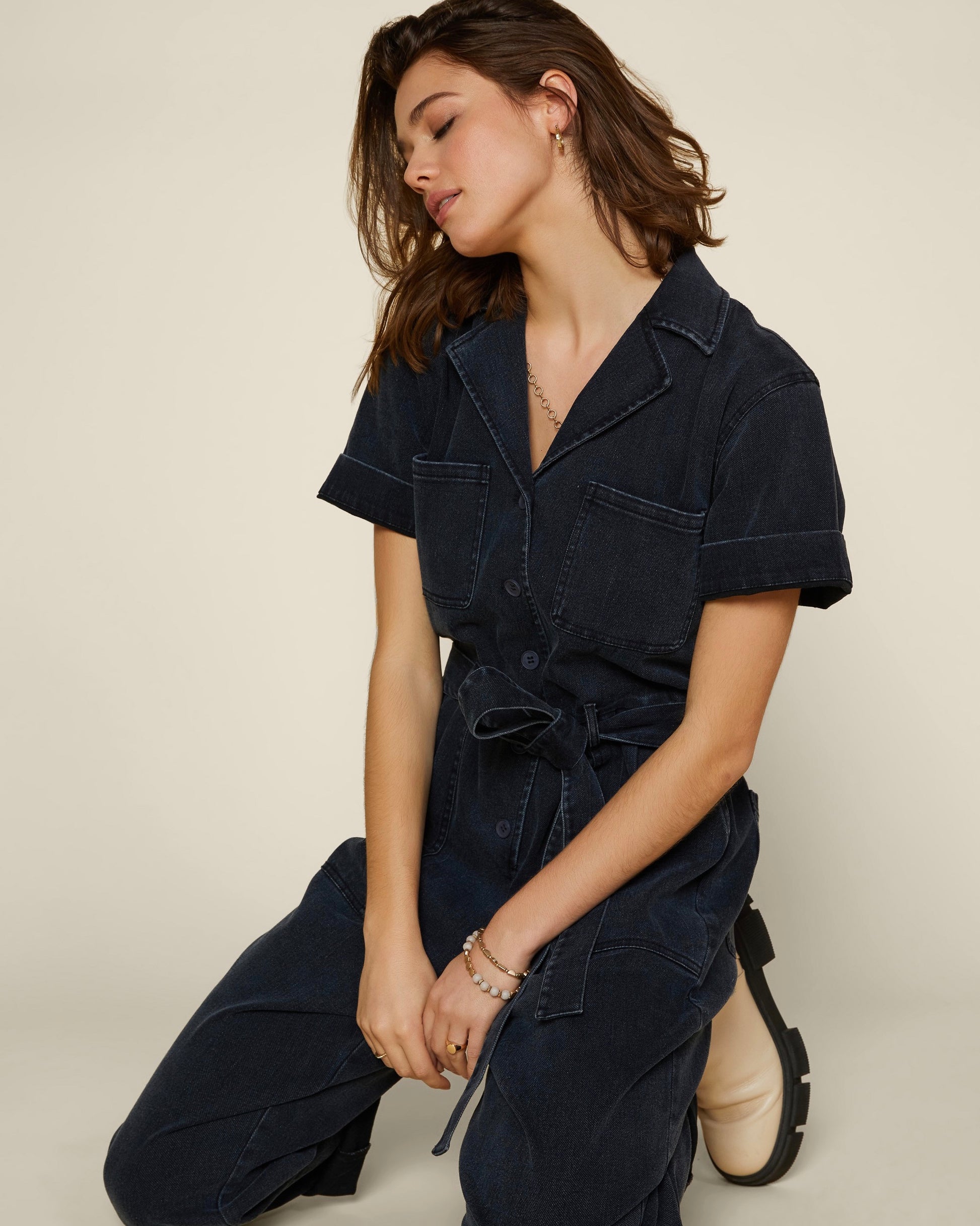 Model wearing Skies are blue utility jumpsuit in black on a white background 